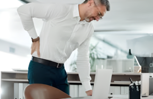 30 வயதிலேயே மூட்டு வலியா? காரணங்களும் அதைத் தடுக்கும் எளிய வழிமுறைகளும்! கணினி முன் அமர்ந்து வேலை செய்யும் போது முதுகு வலியால் அவதிப்படும் ஒரு இளைஞர்